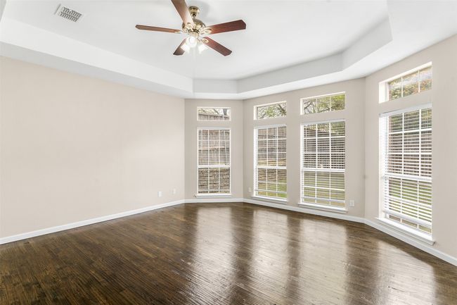 Empty room featuring a ceiling fan, dark wood-type flooring, baseboards, and visible vents | Image 20