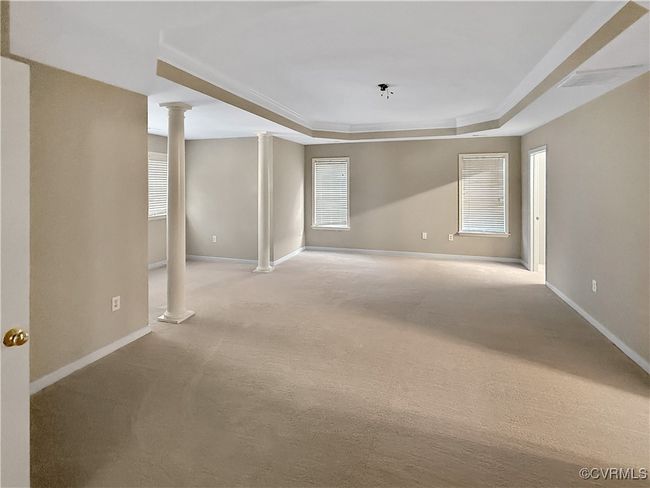 Unfurnished room with ornate columns, a tray ceiling, and carpet | Image 15