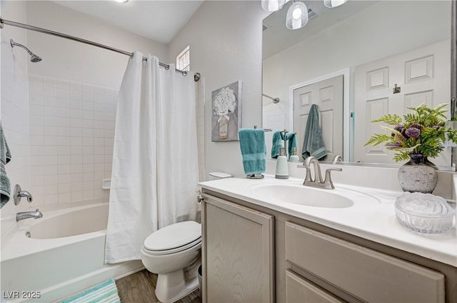 Bathroom with vanity, shower / bath combination with curtain, and wood finished floors | Image 26