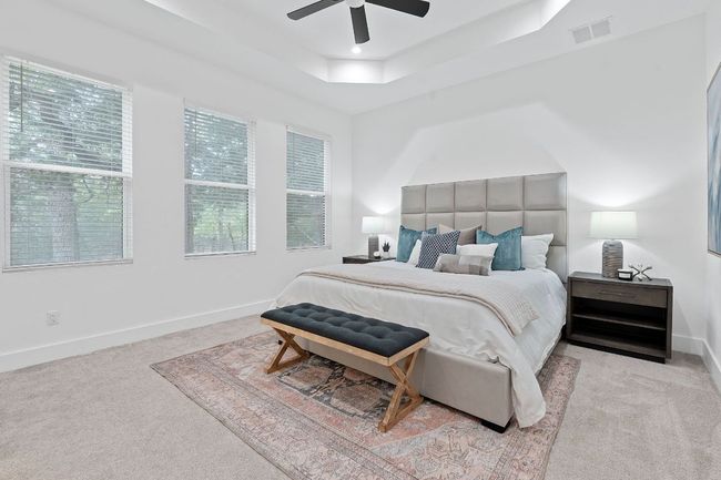 Bedroom with a ceiling fan, visible vents, a raised ceiling, baseboards, and carpet floors | Image 23