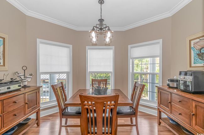Dining space with a chandelier, plenty of natural light, ornamental molding, and light wood-style flooring | Image 11