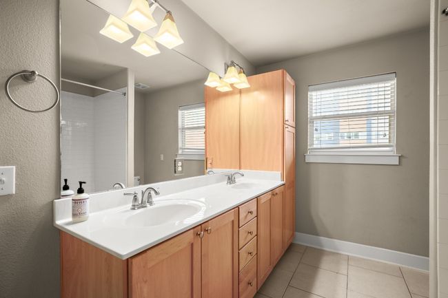 Bathroom with a sink, baseboards, double vanity, and tile patterned floors | Image 17