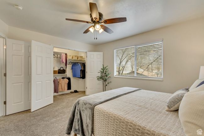 Carpeted bedroom with a closet, ceiling fan, and a walk in closet | Image 10