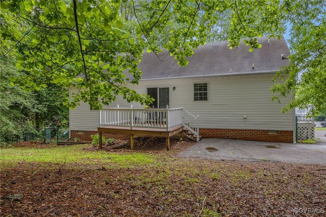 Rear view of house featuring a deck, crawl space, and roof with shingles | Image 24
