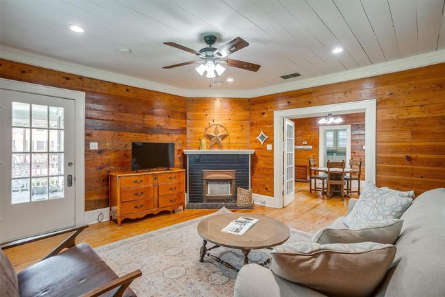 Living room featuring crown molding, recessed lighting, wood walls, light wood finished floors, and a ceiling fan | Image 11