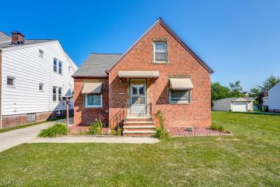 View of front of home with an outdoor structure, a garage, and a front yard | Image 1