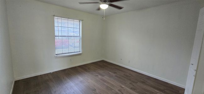 Spare room featuring a ceiling fan and dark wood-style floors | Image 6