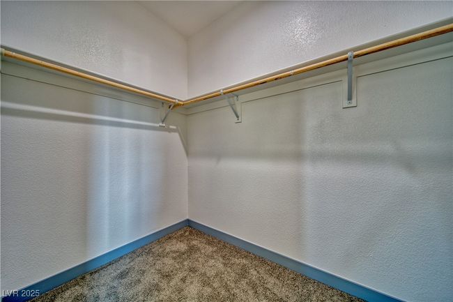 Spacious primary walk-in closet with ample storage space, designed for organization and convenience. | Image 16