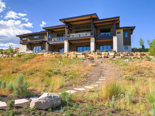 Rear view of property featuring a balcony and stone siding | Image 6