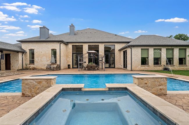 View of swimming pool featuring a pool with connected hot tub and a patio area | Image 36