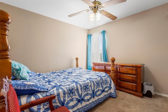 Bedroom with ceiling fan, carpet floors, and a textured wall | Image 20