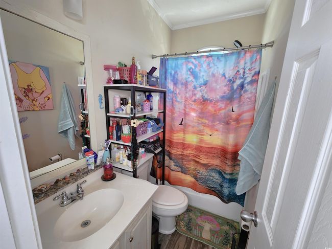 Full bathroom with vanity, crown molding, hardwood / wood-style floors, and shower / bathtub combination with curtain | Image 20