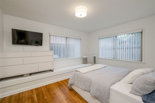 Bedroom with multiple windows and wood finished floors | Image 15