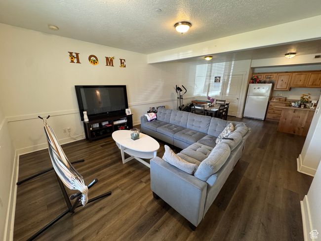 Living room featuring a textured ceiling and dark wood-type flooring | Image 4