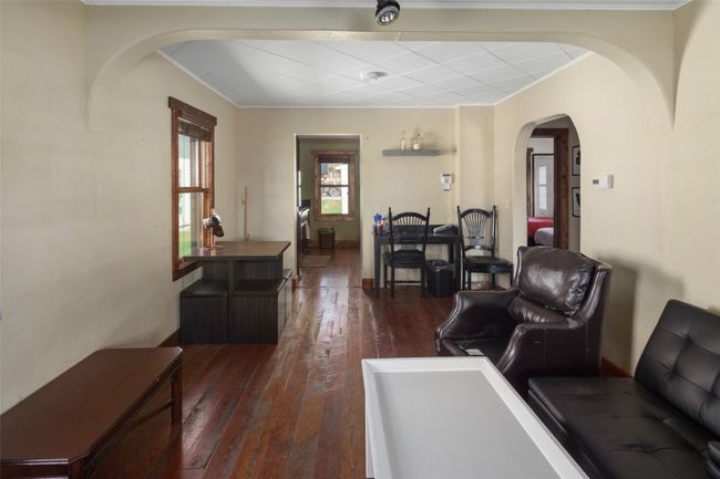Living area with crown molding, arched walkways, and dark wood-style flooring | Image 7