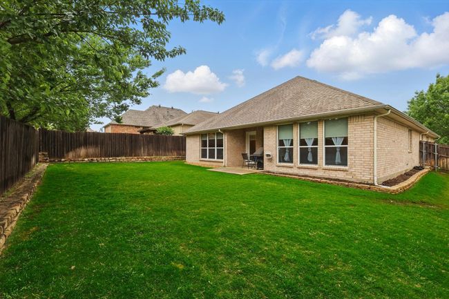Rear view of property featuring roof with shingles, a patio area, brick siding, a fenced backyard, and a yard | Image 37