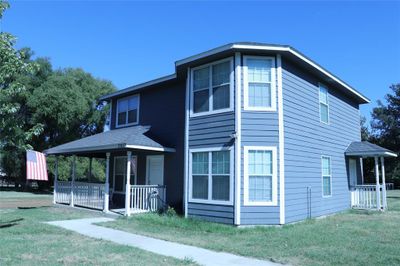 View of front of home featuring a front lawn and covered porch | Image 1