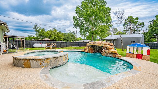Swimming pool, hot tub, rock feature, & patio area | Image 21