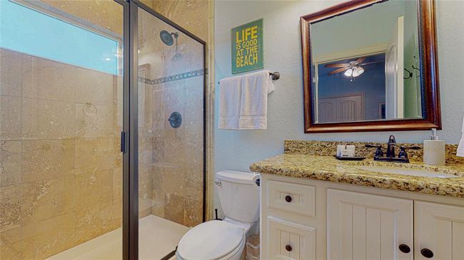 Spacious primary bedroom with an accessible walk-in shower and a generous vanity space, providing both comfort and functionality. | Image 22