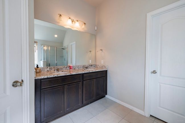 Bathroom with double vanity, tile patterned flooring, and a stall shower | Image 14
