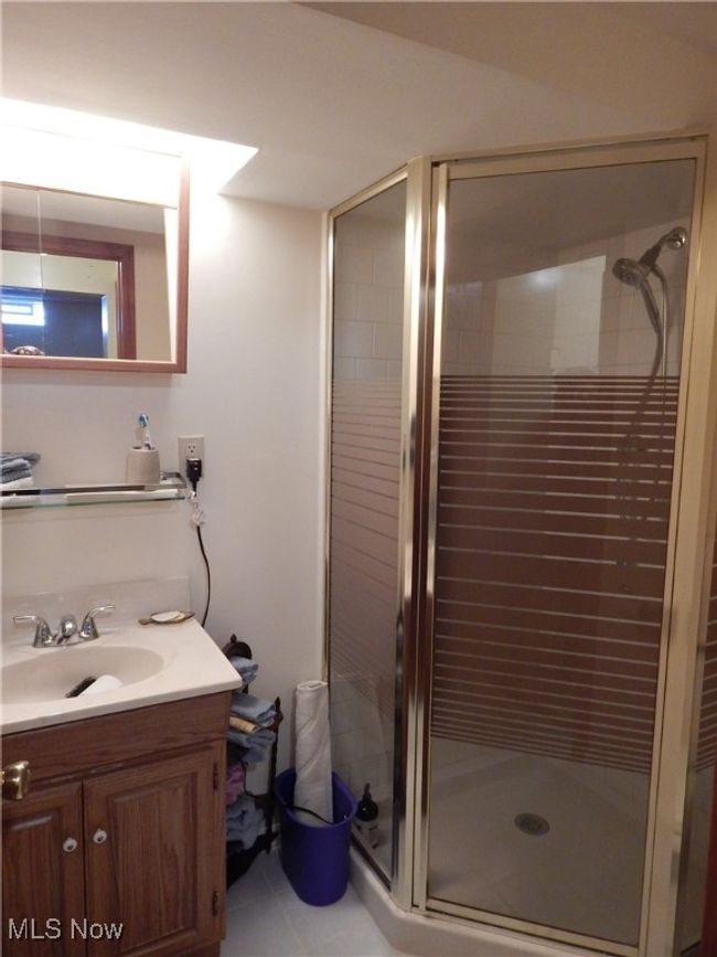 Basement full Bathroom featuring a shower stall, vanity & toilet. | Image 27