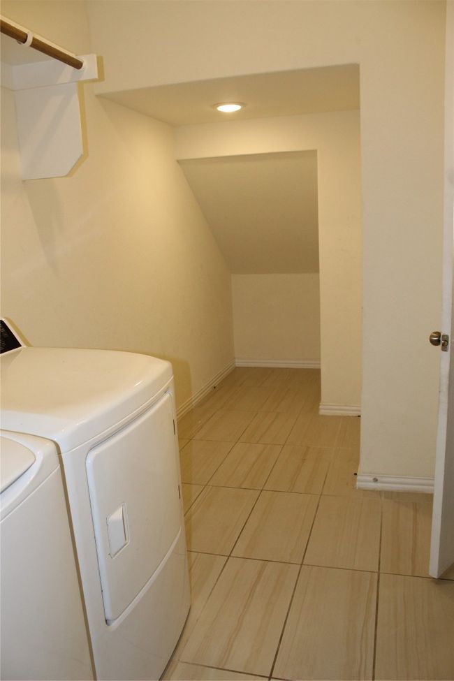 Washroom with washing machine and clothes dryer, light tile patterned floors, baseboards, and recessed lighting | Image 19