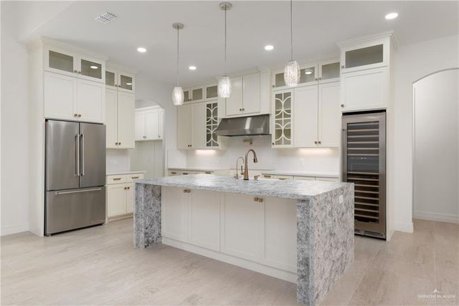 The expansive island provides ample seating and prep space, ideal for hosting guests or enjoying everyday meals in luxury. | Image 9