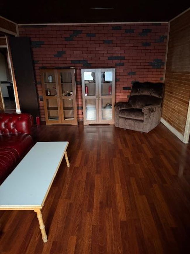 Living room featuring french doors, wood finished floors, and brick wall | Image 17
