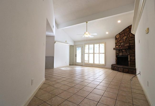 Spacious family room is highlighted by a charming fireplace, high ceiling, natural lights | Image 4