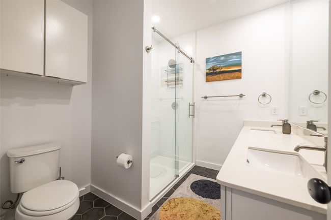 Full bathroom featuring a shower stall, tile patterned floors, a sink, and toilet | Image 23