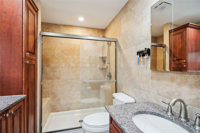 Full bath with vanity, tile walls, a shower stall, and decorative backsplash | Image 11