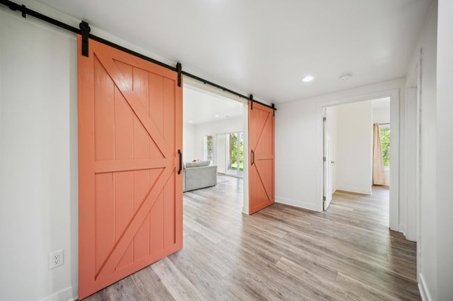 Beautiful, oversized barn doors gracefully separate the cozy family room from the private bedroom suite, bathroom, and utility area—offering both charm and functional separation for everyday living. | Image 32