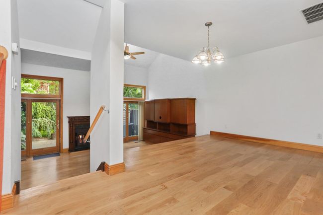 Empty room featuring wood finished floors, ceiling fan, baseboards, and high vaulted ceiling | Image 15