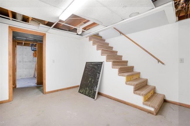 Lower level central room leads to an office & unfinished storage | Image 14