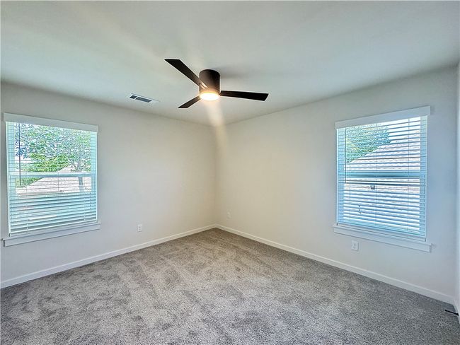 The secondary bedroom is a cozy and comfortable space, with ample room for a bed and additional furniture | Image 18