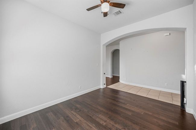 Unfurnished room featuring visible vents, arched walkways, wood finished floors, and a ceiling fan | Image 10
