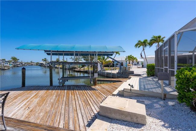 View of dock featuring covered boat lift, a lanai, and a water view | Image 23