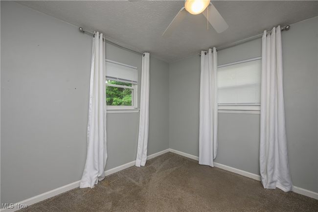 Unfurnished room featuring a ceiling fan, carpet flooring, and a textured ceiling | Image 11