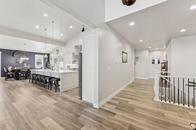 Hallway featuring an upstairs landing, an inviting chandelier, recessed lighting, and light wood finished floors | Image 8