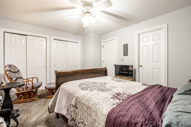 primary bedroom featuring a ceiling fan and double closets | Image 16