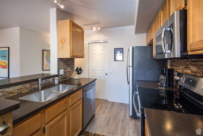 Kitchen featuring decorative backsplash, kitchen peninsula, sink, and appliances with stainless steel finishes | Image 16