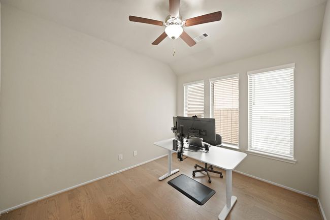 Transform your work routine into ahaven of productivity and comfort inthis thoughtfully designed homeoffice. Featuring large windows, high ceiling, and a ceiling fan. | Image 18