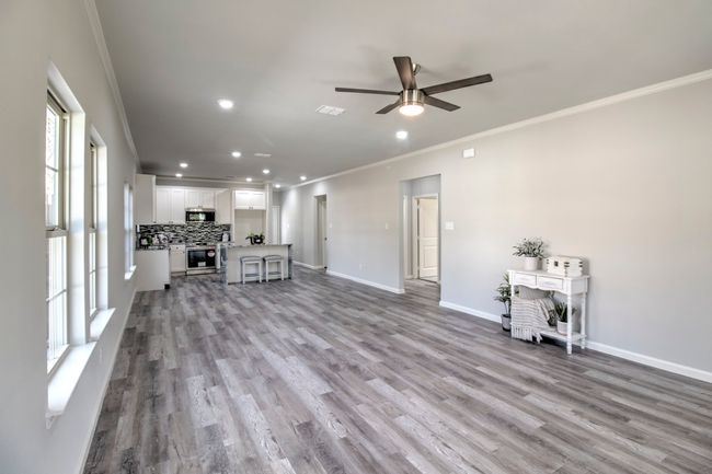 Unfurnished living room featuring crown molding, a ceiling fan, recessed lighting, and wood finished floors | Image 5