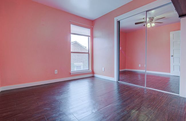 Unfurnished bedroom with wood finished floors, a closet, a ceiling fan, and baseboards | Image 12