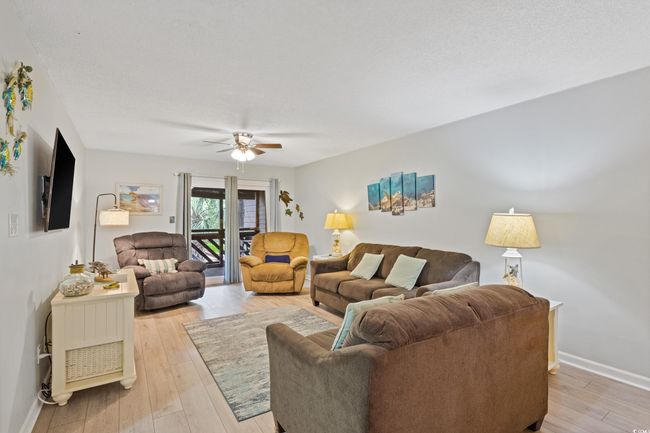 Living area featuring baseboards, ceiling fan, and light wood finished floors | Image 13