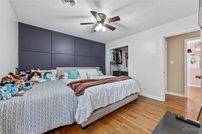 Bedroom with light wood finished floors, visible vents, ceiling fan, and baseboards | Image 22