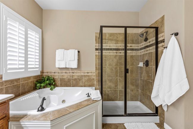 Full bath with a whirlpool tub, a shower stall, vanity, and tile patterned floors | Image 24