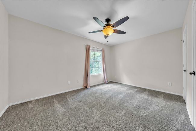 Carpeted empty room with ceiling fan and baseboards | Image 25