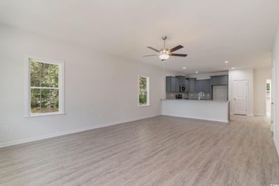 Unfurnished living room featuring light hardwood / wood-style floors, sink, and ceiling fan | Image 2