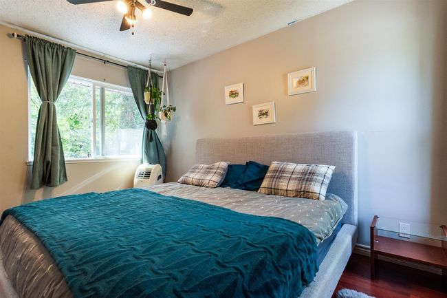 Bedroom featuring wood finished floors, a textured ceiling, and a ceiling fan | Image 16